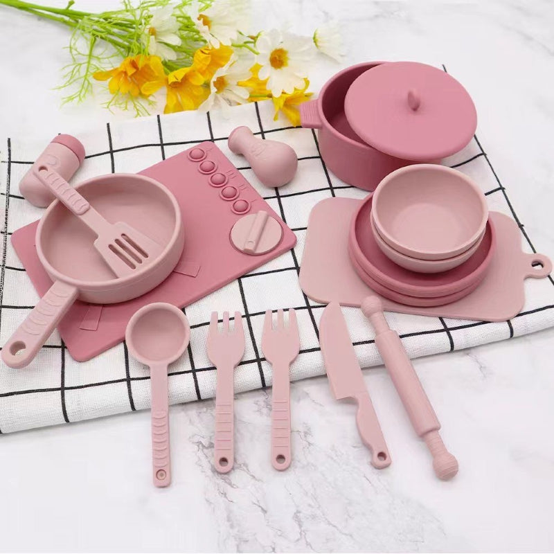 Pink silicone kitchenware set on a checkered cloth with flowers in the background